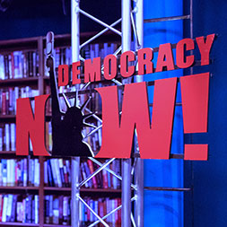 Democracy Now sign. Links to What to Give Democracy Now sign. Links to What to Give