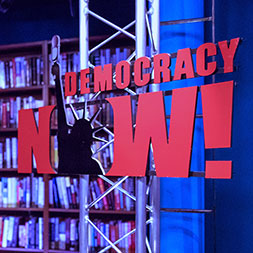 Photo of Democracy Now! logo on a wall. 